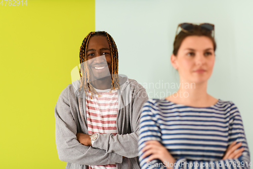 Image of afro guy and european woman with arms crossed posing in studio