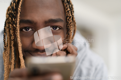 Image of afro guy uses a cell phone and browses social media during a pandemic