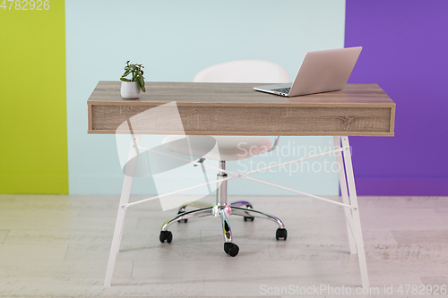 Image of home office concept. chair, laptop, desk and flowers.