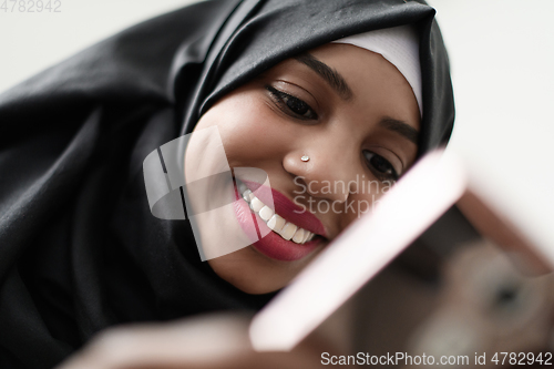 Image of afro girl uses a cell phone and browses social media during a pandemic