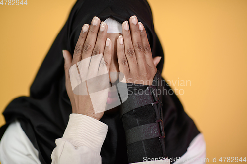 Image of african muslim woman wearing hijab and traditional muslim clothes posing in front of green background