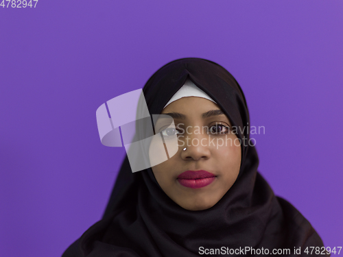 Image of portrait of african muslim woman wearing hijab and traditional muslim clothes posing in front of purple background