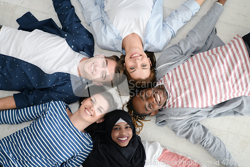 Image of top view of a diverse group of people lying on the floor and symbolizing togetherness