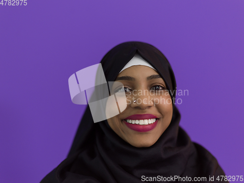 Image of portrait of african muslim woman wearing hijab and traditional muslim clothes posing in front of purple background