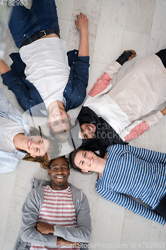 Image of top view of a diverse group of people lying on the floor and symbolizing togetherness