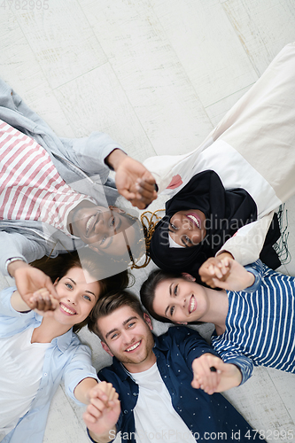 Image of top view of a diverse group of people lying on the floor and symbolizing togetherness