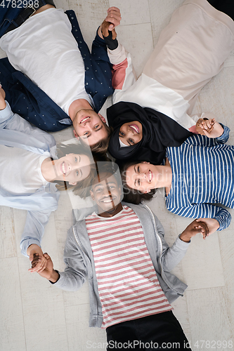 Image of top view of a diverse group of people lying on the floor and symbolizing togetherness