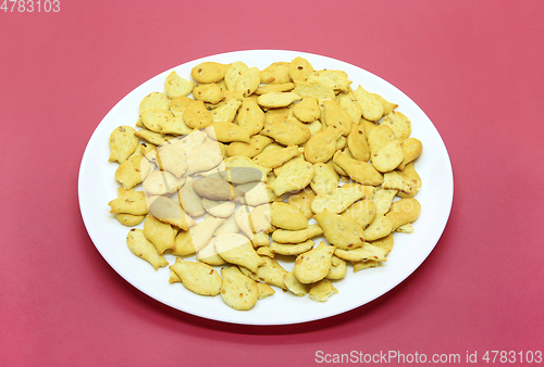 Image of Fish-shaped cookies in a white plate on a crimson background 