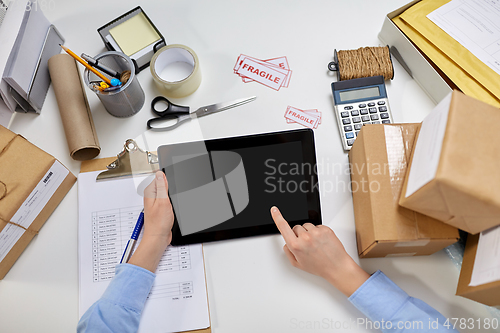 Image of hands with tablet pc and clipboard at post office