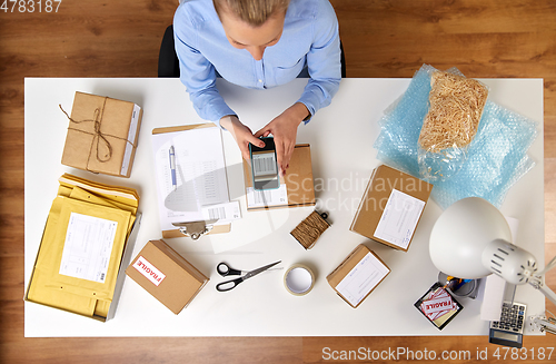 Image of woman with smartphone scans barcode on parcel box