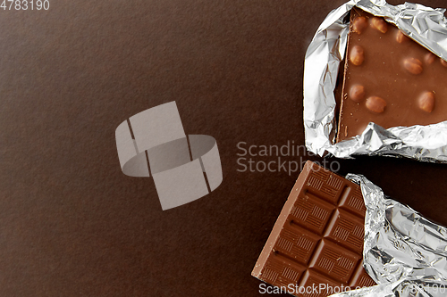 Image of milk chocolate bar with nuts in foil wrapper