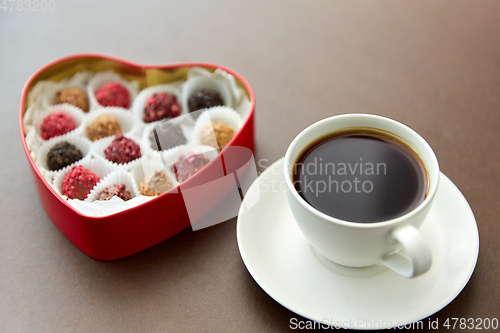 Image of candies in heart shaped chocolate box and coffee