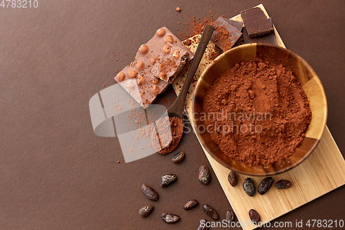 Image of chocolate with hazelnuts, cocoa beans and powder