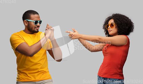 Image of african couple in sunglasses making gun gesture