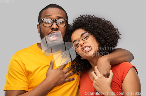 Image of happy african american couple in glasses hugging