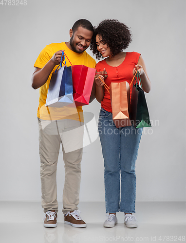 Image of happy african american couple with shopping bags