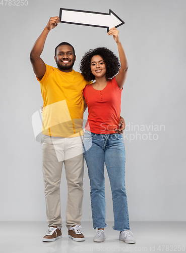 Image of happy african american couple holding arrow