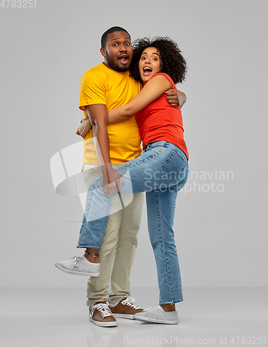 Image of scared african american couple hugging