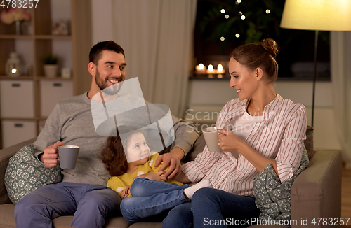 Image of portrait of happy family sitting on sofa at home