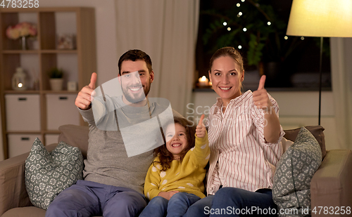 Image of portrait of happy family sitting on sofa at home