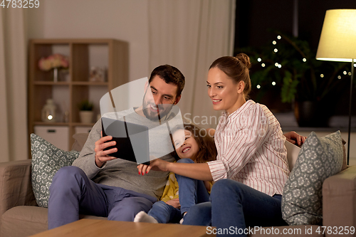 Image of happy family with tablet computer at home at night