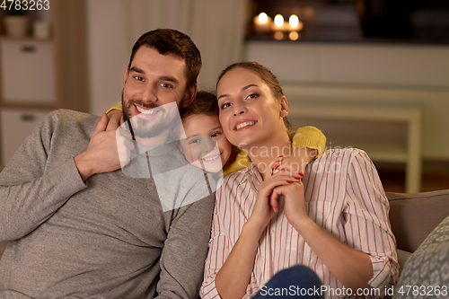 Image of portrait of happy family sitting on sofa at home