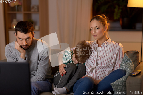 Image of family watching something boring on tv at night