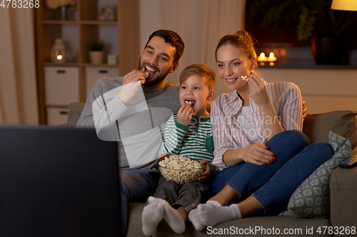 Image of happy family with popcorn watching tv at home