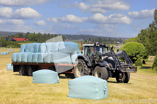 Image of Tractor Pulling Trailer Full of Silage Bales