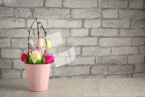 Image of Flowers, willow twigs and easter eggs in basket in as Easter gift