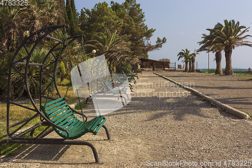 Image of Deserted swing benches in a city park at a seaside resort