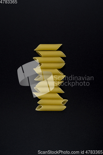 Image of Macaroni on black background in flat lay