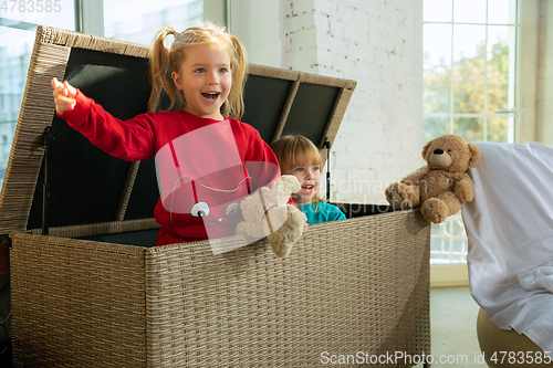 Image of Little girls in soft warm pajamas playing at home