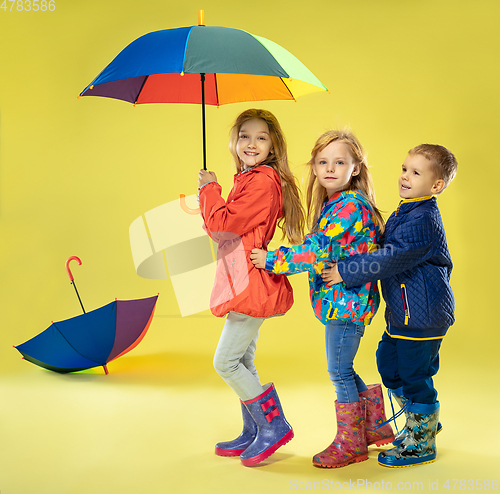 Image of A full length portrait of a bright fashionable kids in a raincoat