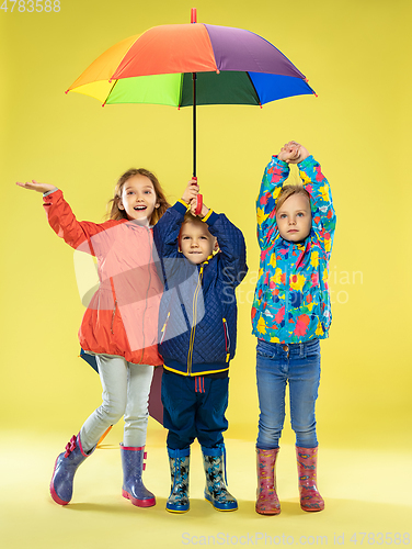 Image of A full length portrait of a bright fashionable kids in a raincoat