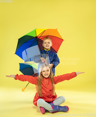 Image of A full length portrait of a bright fashionable kids in a raincoat