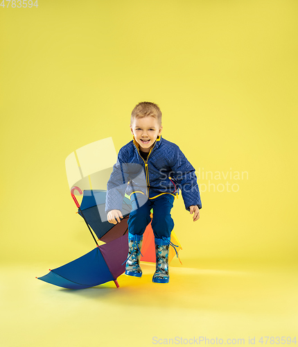 Image of A full length portrait of a bright fashionable kid in a raincoat