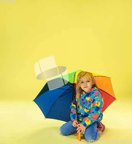 Image of A full length portrait of a bright fashionable girl in a raincoat