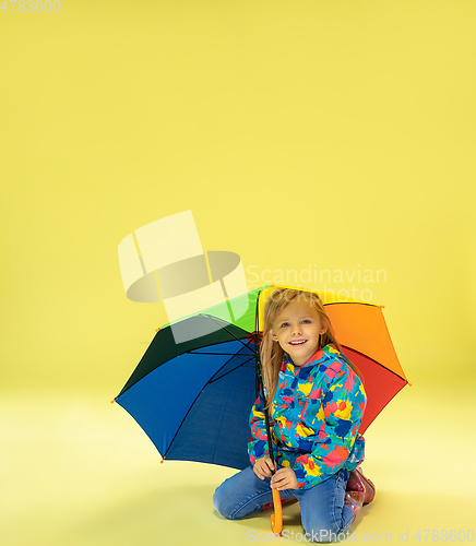 Image of A full length portrait of a bright fashionable girl in a raincoat