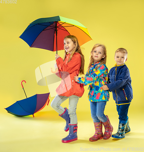 Image of A full length portrait of a bright fashionable kids in a raincoat