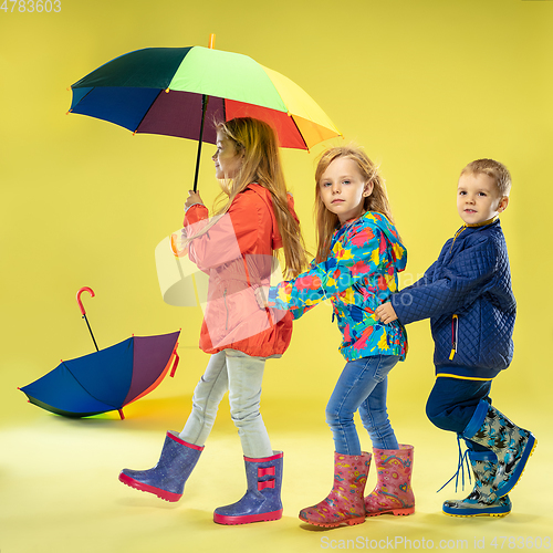 Image of A full length portrait of a bright fashionable kids in a raincoat