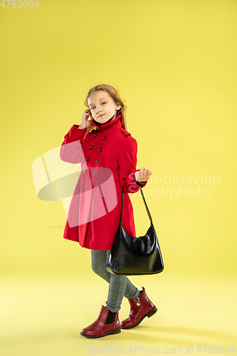 Image of A full length portrait of a bright fashionable girl in a raincoat