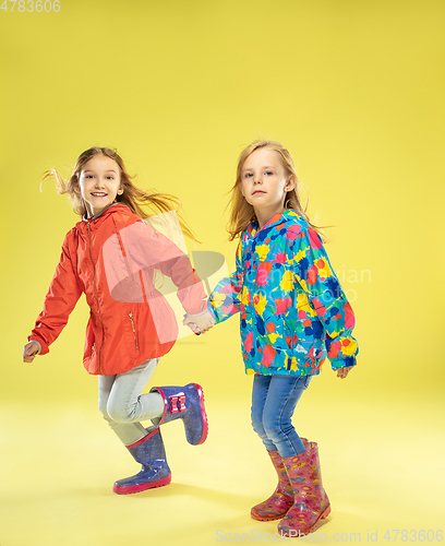 Image of A full length portrait of a bright fashionable girls in a raincoat