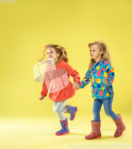 Image of A full length portrait of a bright fashionable girls in a raincoat
