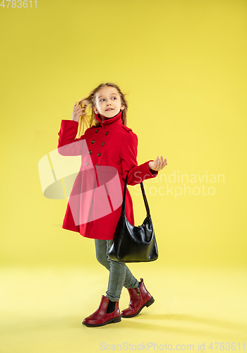 Image of A full length portrait of a bright fashionable girl in a raincoat