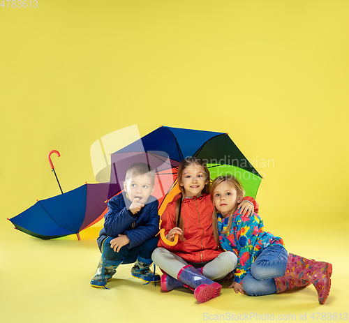 Image of A full length portrait of a bright fashionable kids in a raincoat