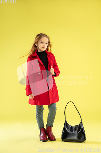 Image of A full length portrait of a bright fashionable girl in a raincoat