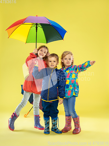 Image of A full length portrait of a bright fashionable kids in a raincoat