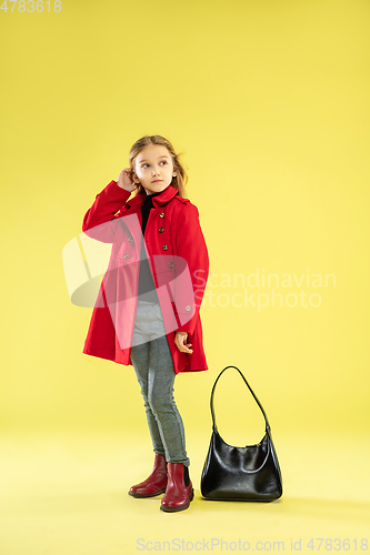 Image of A full length portrait of a bright fashionable girl in a raincoat