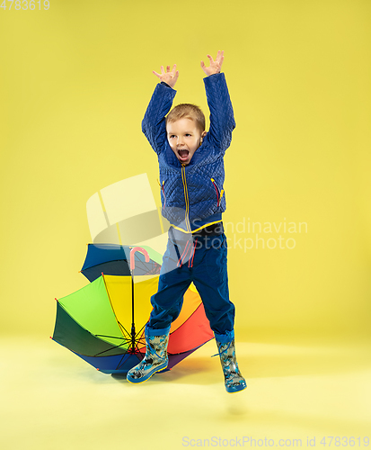 Image of A full length portrait of a bright fashionable kid in a raincoat